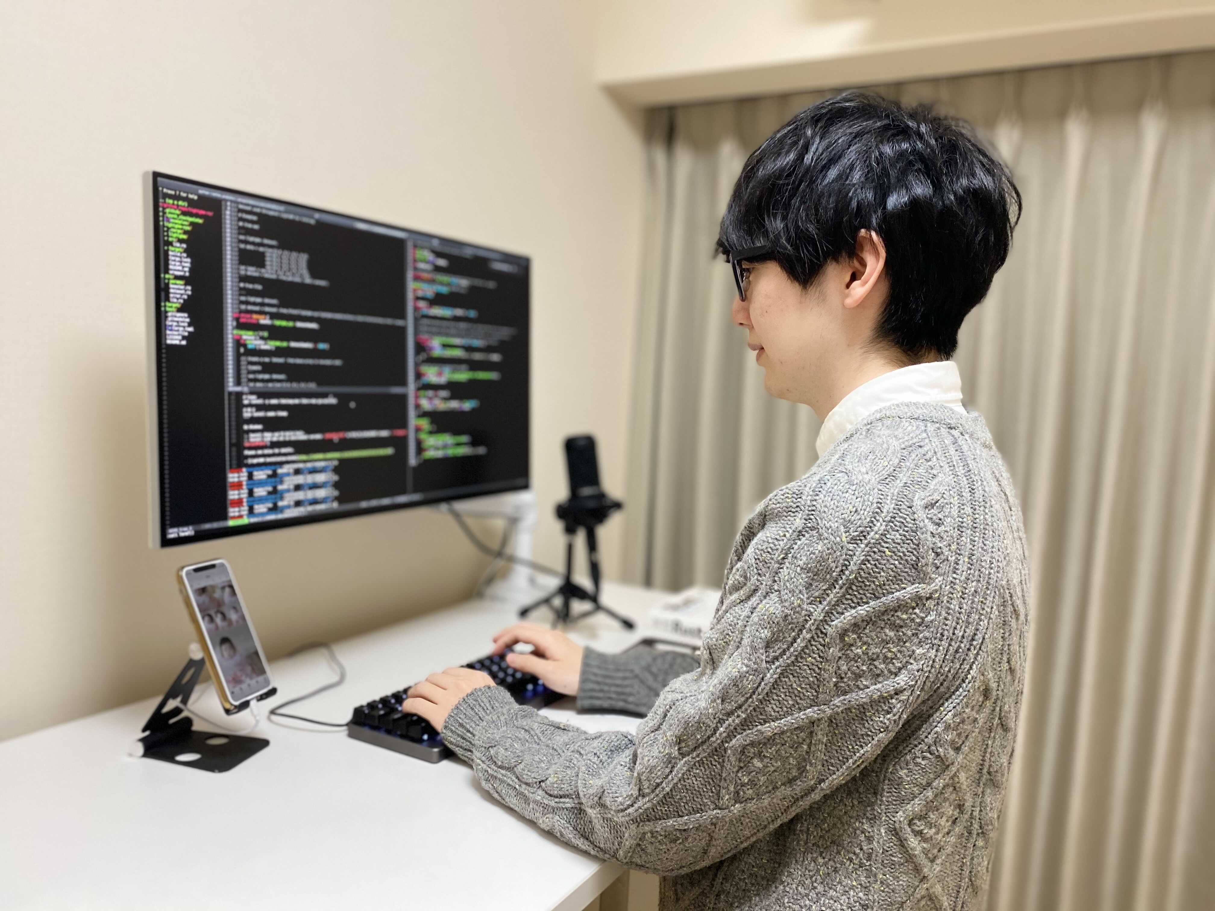 これは私のデスクです。夜中は特に座っていると眠くなってしまうので、昇降デスクの高さを調節して立って執筆しています。 これは私のデスクです。夜中は特に座っていると眠くなってしまうので、昇降デスクの高さを調節して立って執筆しています。
