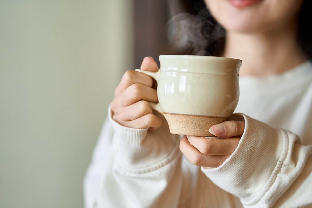 温かい飲み物を飲んでリラックスする女性