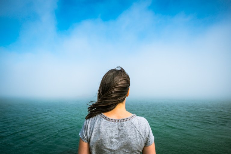 海に向かって立つ女性