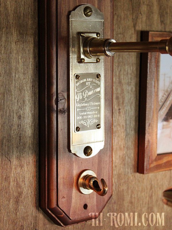 シリアルナンバーが彫られた真鍮プレートと小さなフック|壁掛け照明