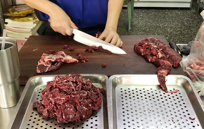 店内でスライスされる新鮮な牛肉