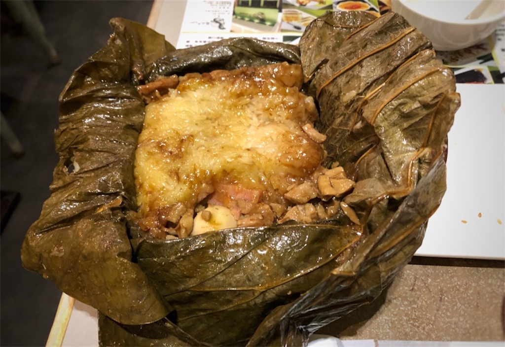 蓮の葉を広げるとみえるお肉が乗ったちまき