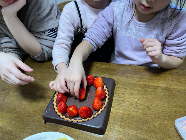 チョコレートタルトにイチゴをトッピングするちびっ子ギャングたち