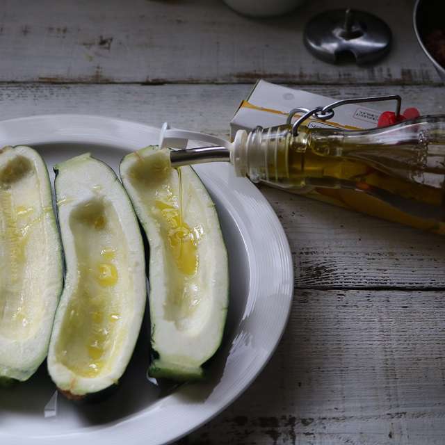 ズッキーニにオリーブオイルを小さじ1/2流し込み、ラップをかけて3分レンジ加熱