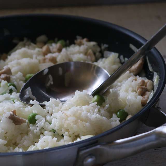 お玉の底でご飯をフライパンに押し付けるように