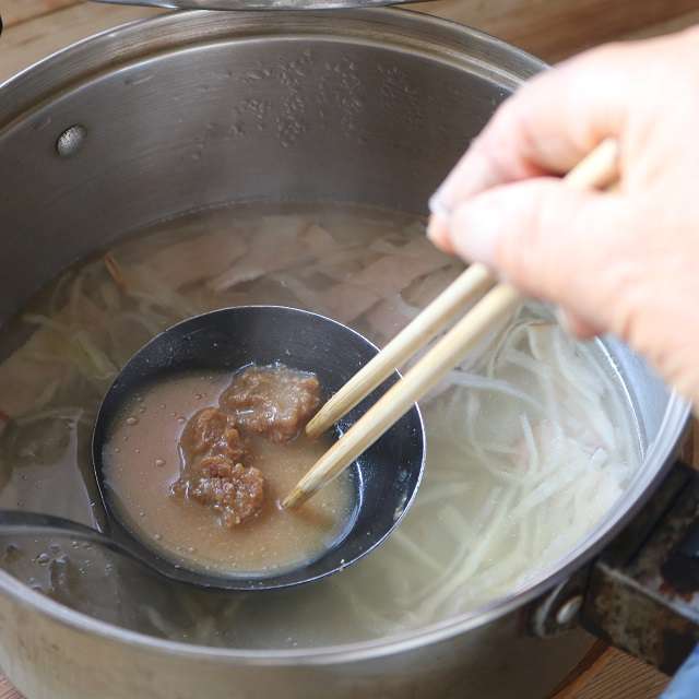 お玉に鍋の中の湯を取って味噌を溶かして戻す