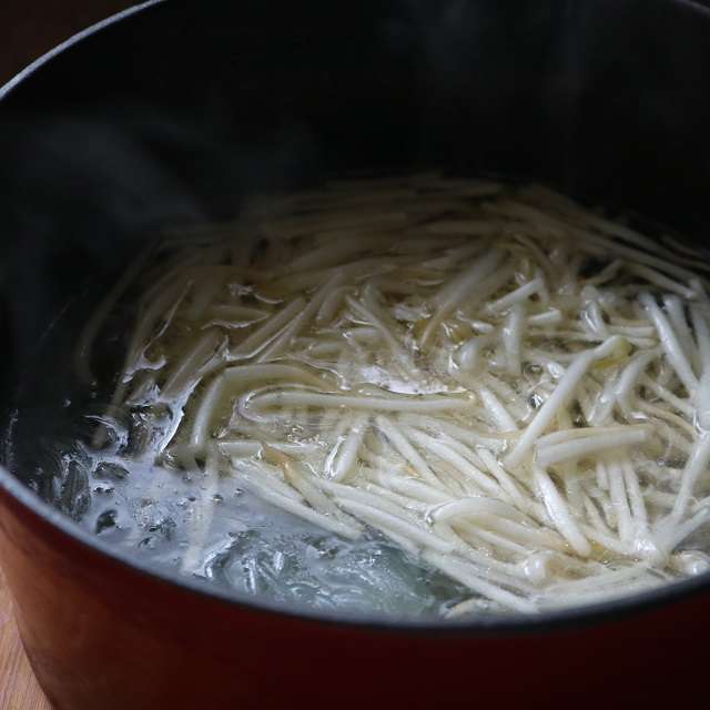 鍋から鶏皮を取り出し、調味料で味を調え、春雨を入れてモヤシを加え、沸騰するまで煮る