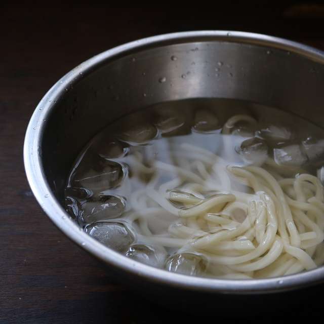 冷凍うどんを温め、ザルに上げて冷水に取る