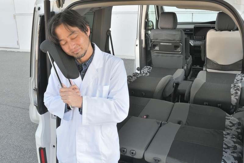 Car寝る博士がステップワゴンの近くに立ってヘッドレストに頬ずりしている写真