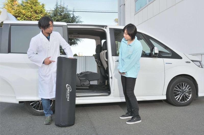 Car寝る博士がステップワゴン スパーダの前で、厚手のエアマットであるOnlyStyleを指さしている写真