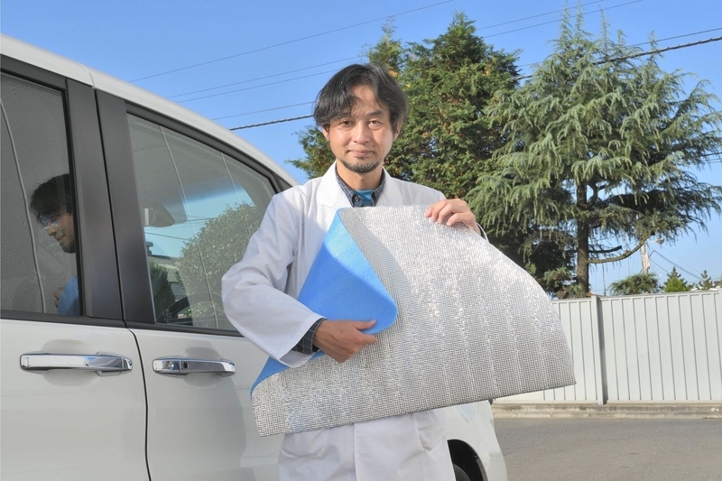 Car寝る博士がステップワゴンスパーダの横で、ウインドウ枠にあわせてカットした銀マットを持っている写真