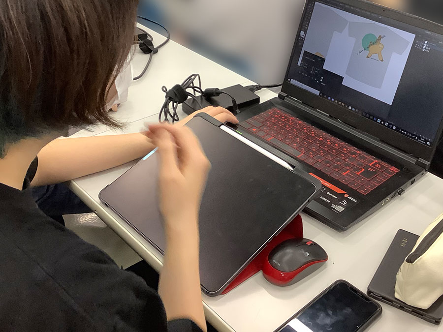 専門学校HALの学生さんがシートベルトが似合うTシャツをデザインしている写真