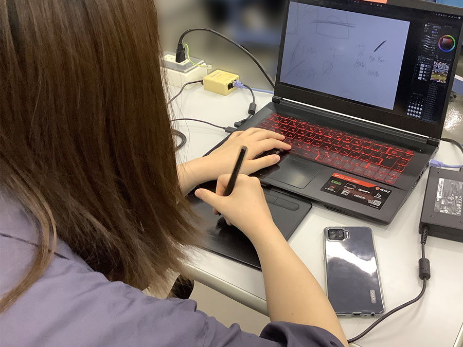 専門学校HALの学生さんがシートベルトが似合うTシャツをデザインしている写真