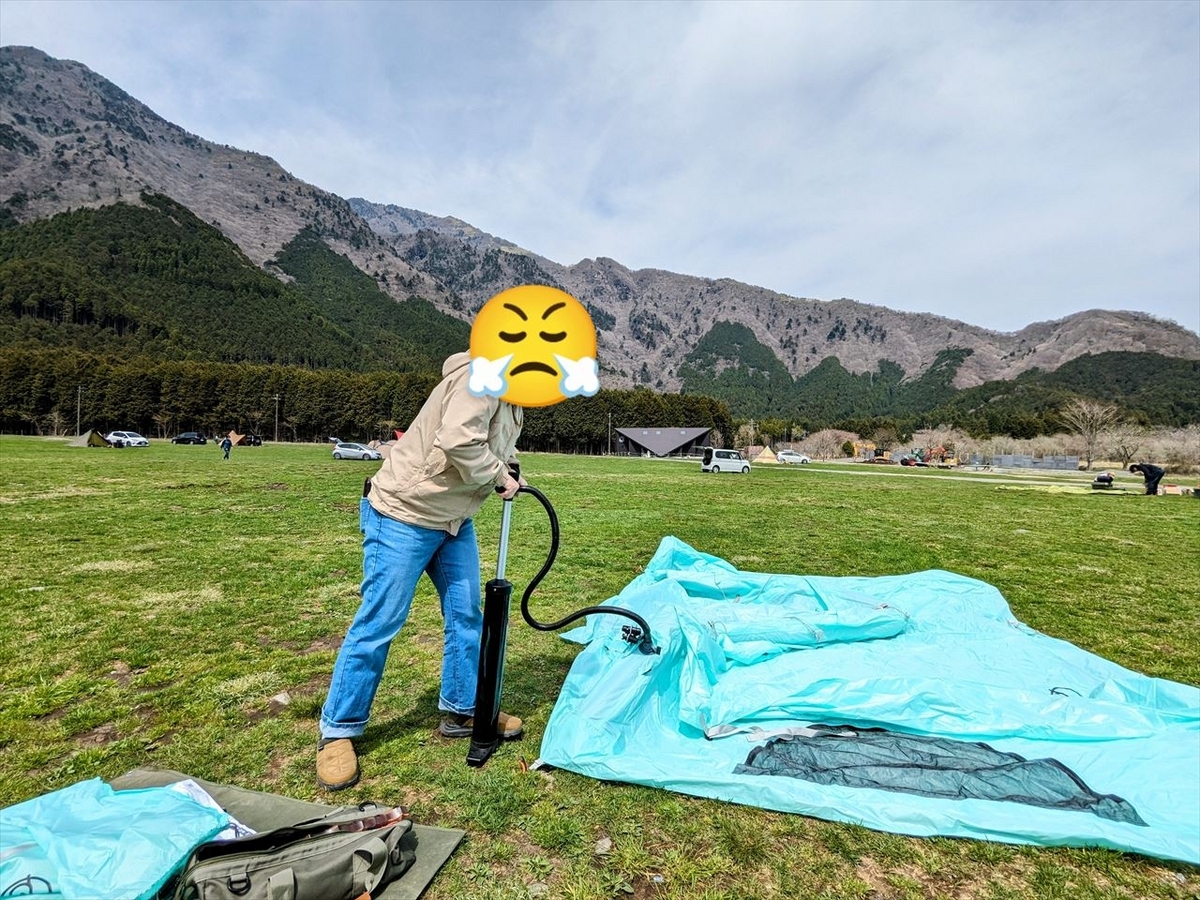 女子キャンパーがインフレータブルテントに空気を注入