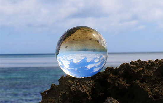 海辺に置かれた神秘的な水晶だまの画像