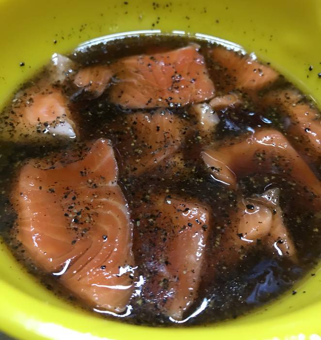 麺つゆとごま油と柚子胡椒が入っているボール入れたサーモン