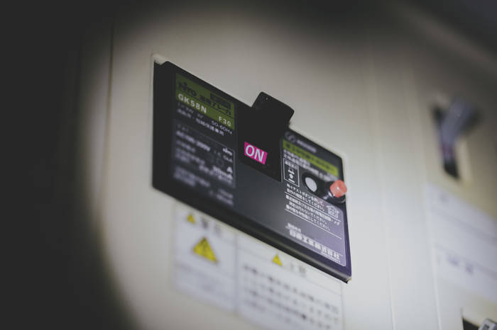 懐中電灯に照らされている停電中のブレーカー
