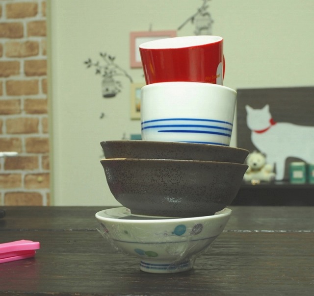 お椀に業務用ラップをぴったり張って、その上にお椀とかコップを重ねた様子