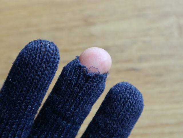 中指の先に大きな穴があいた手袋の写真
