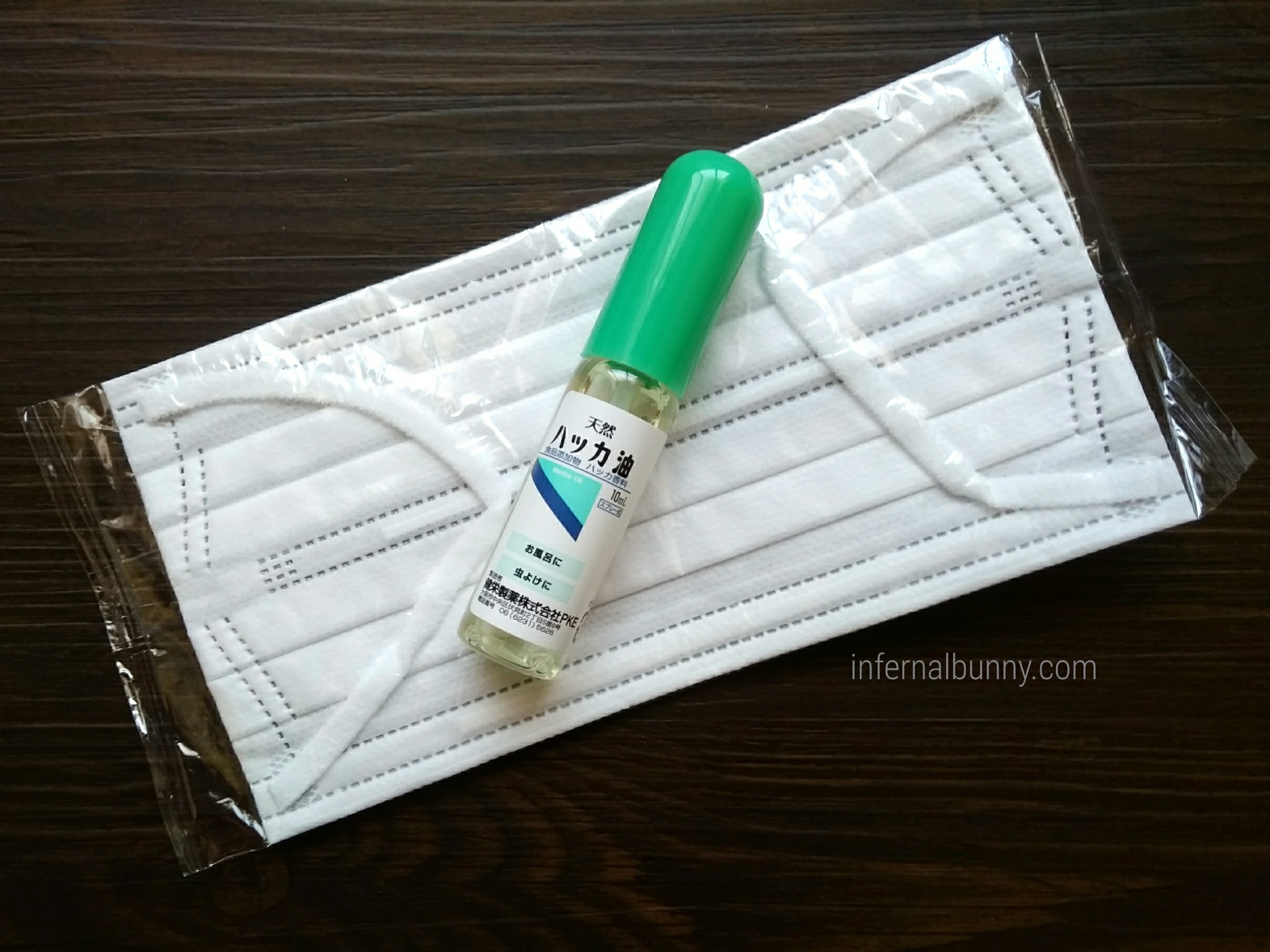 白い不織布マスクとハッカスプレー。
