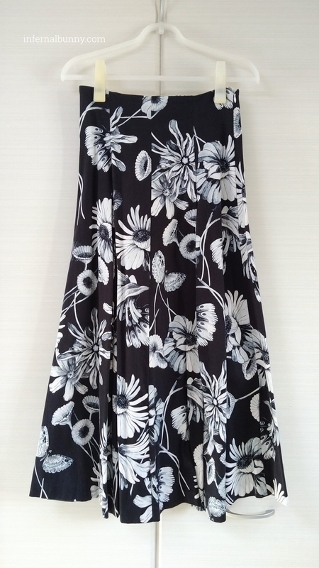 ネイビー地に昆虫と花の柄のフレアロングスカート。