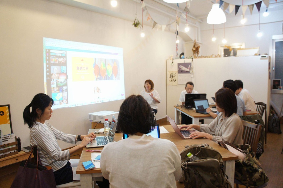 会場風景：正方形のテーブルに各3名がノートパソコンでいろいろ作業をしています