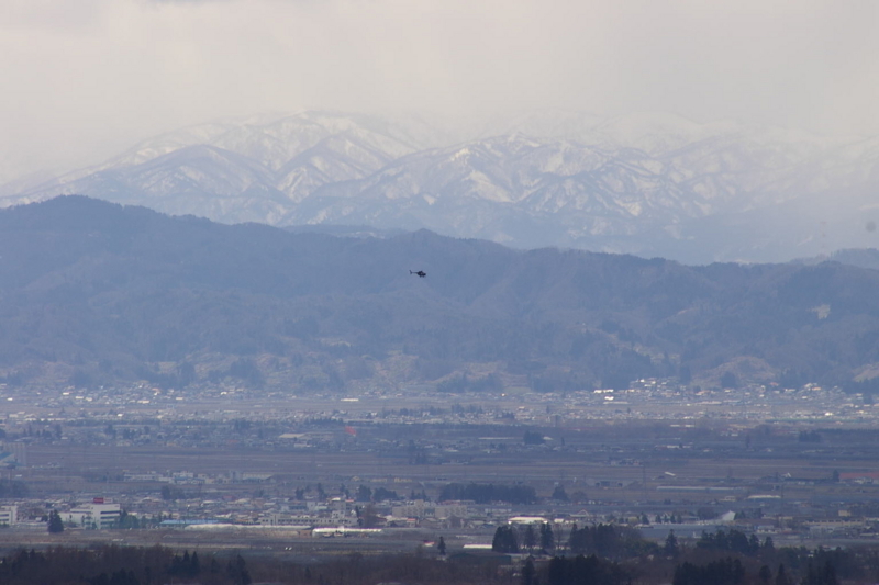 遠くには、朝日連峰を背景に自衛隊のヘリコプターが飛んでいます。