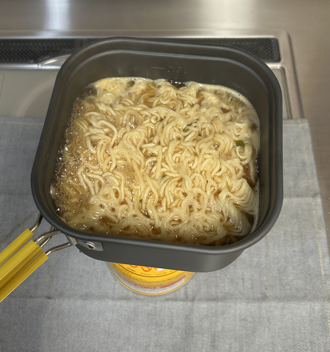 茹でている麺に粉末スープを入れて煮込んでいる様子