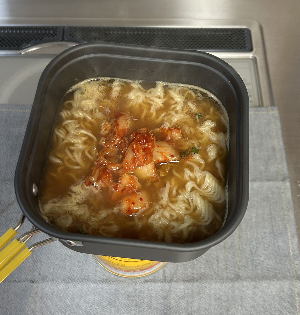 茹で上がった麺にキムチをトッピングして出来上がった様子