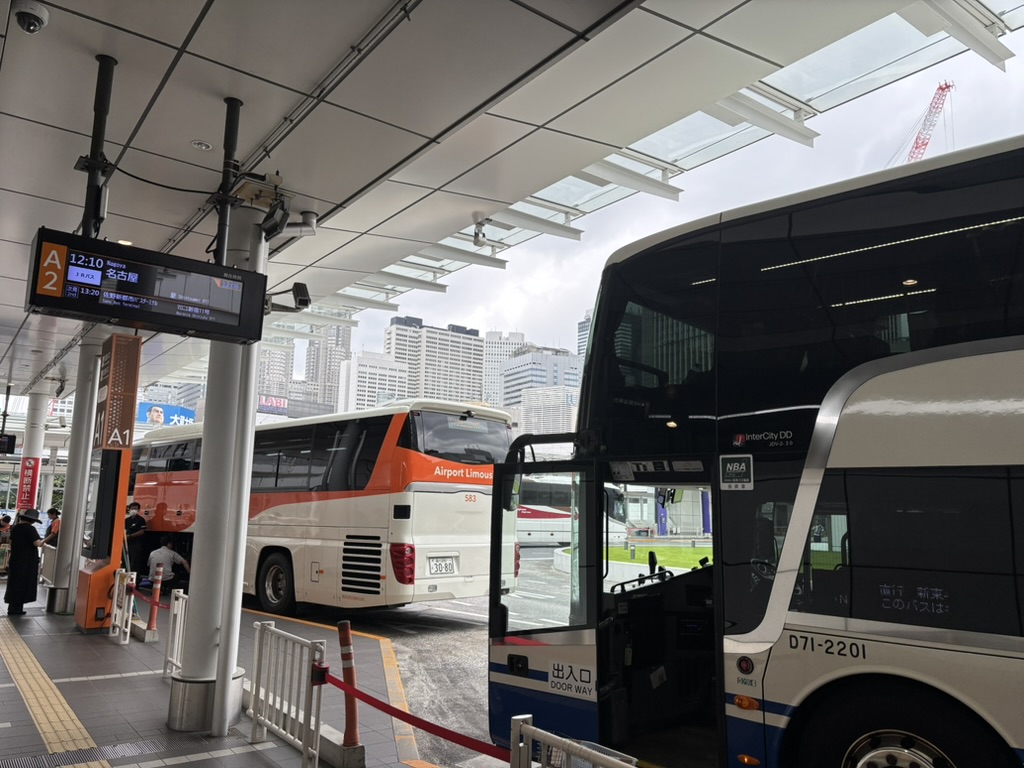 バスターミナルの乗り場から道路側を写した写真。乗車するバス車両と、「名古屋」と表示された発車標が写っている。