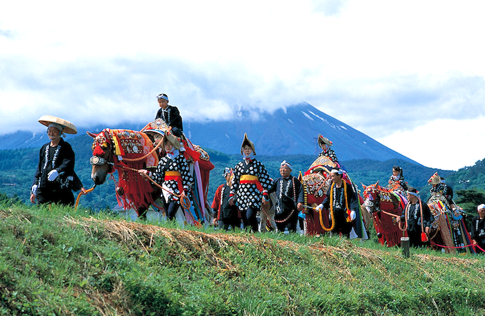 岩手山を背に田園風景の中を進むチャグチャグ馬コの行列