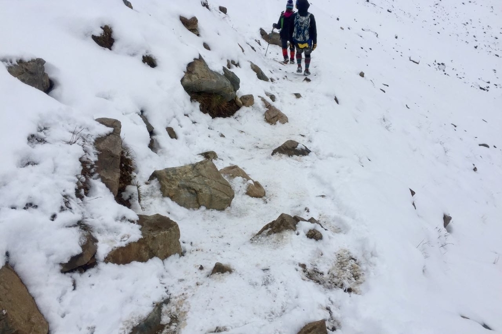 センチネルパスの雪に覆われた山道に石が転がっている。