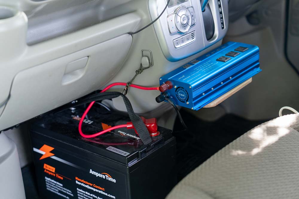 助手席足元に鎮座するモバイル電源と、その電力をコンセントでも使えるようにするインバーター