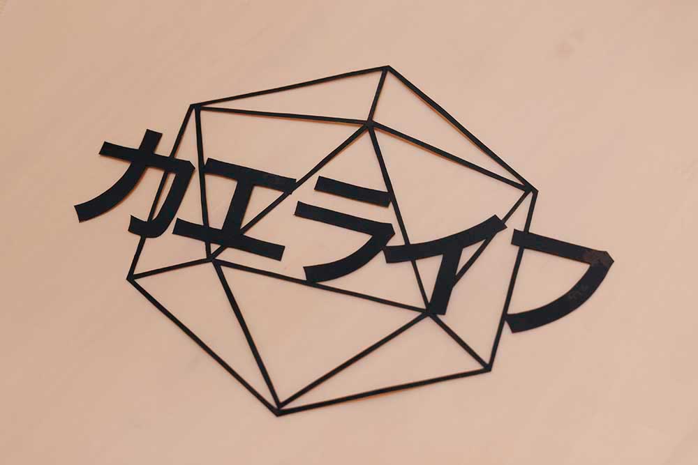 はっしーはっぴーさん得意の切り絵でかたどられた「カエライフ」の文字