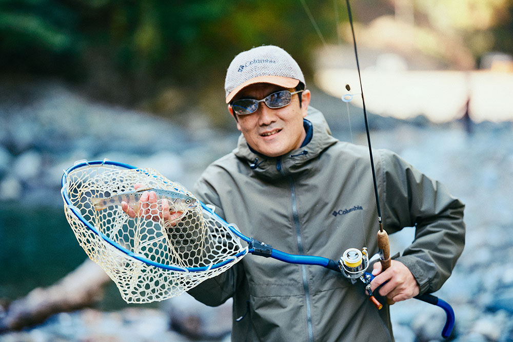 鮎沢さんと網に入ったヤマメ