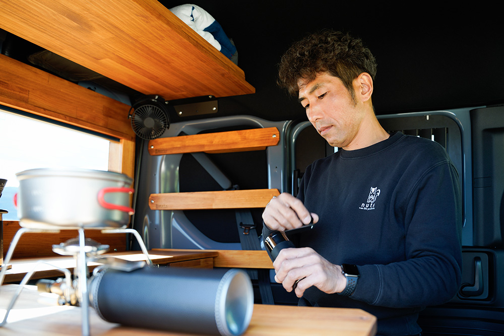 車内でコーヒー豆を挽く男性