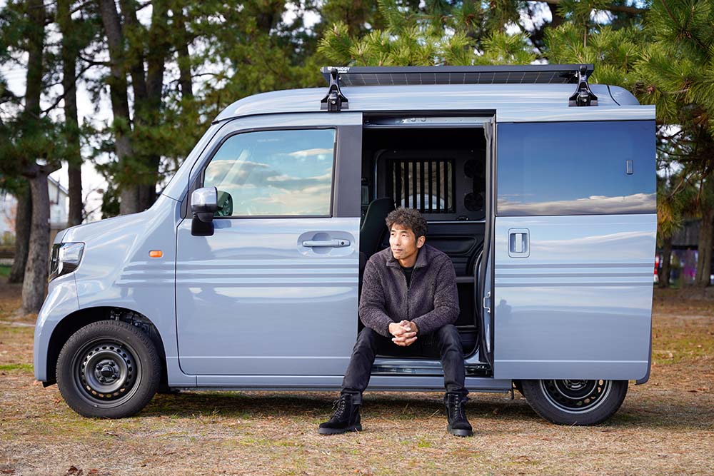 N-VANの後部座席のドアを開け腰掛ける休憩時間さん