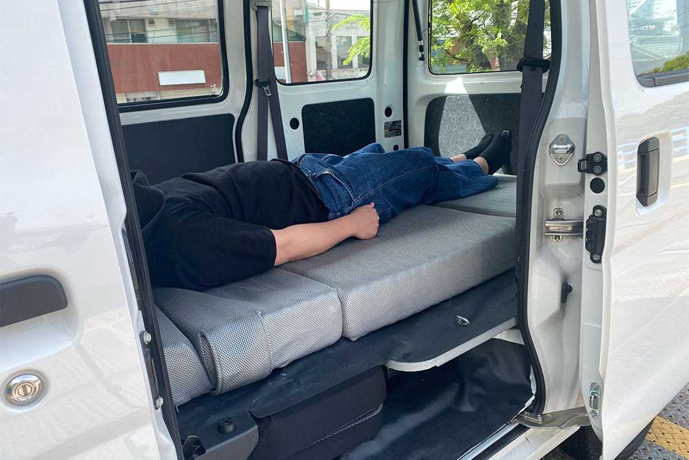 トヨタ ピクシスバンで車中泊をする男性