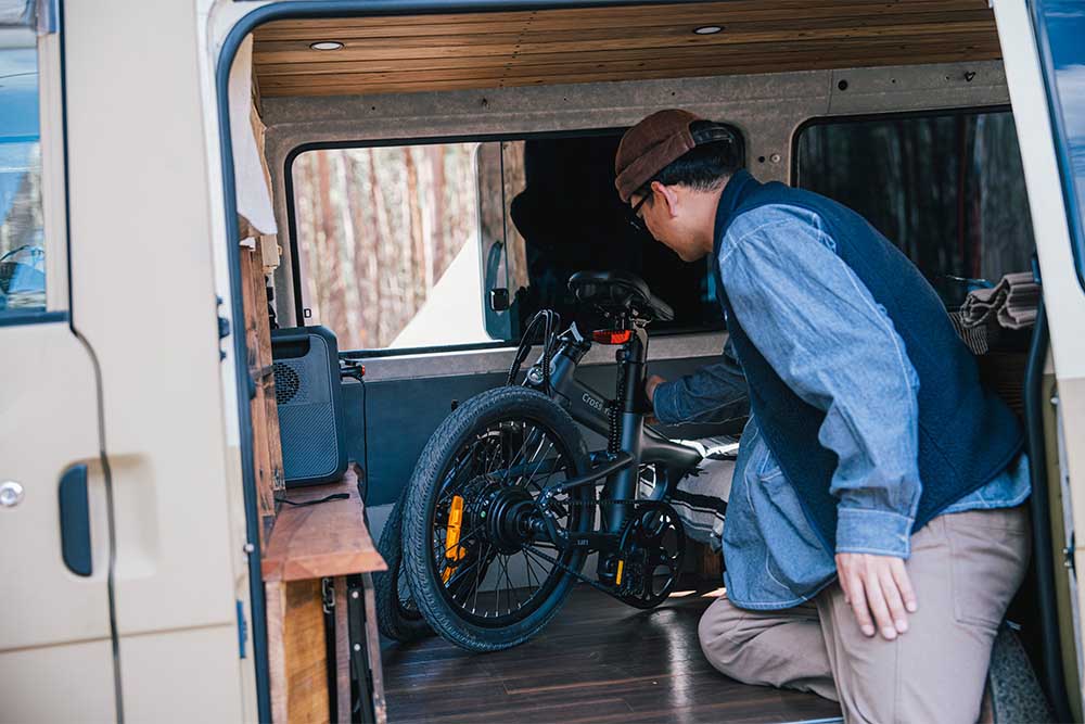 折り畳んだ自転車をバン内に積んでいる様子