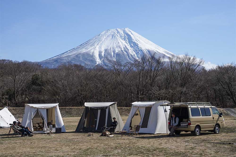 富士山を背景にテント仲間たちとキャンプをしている様子