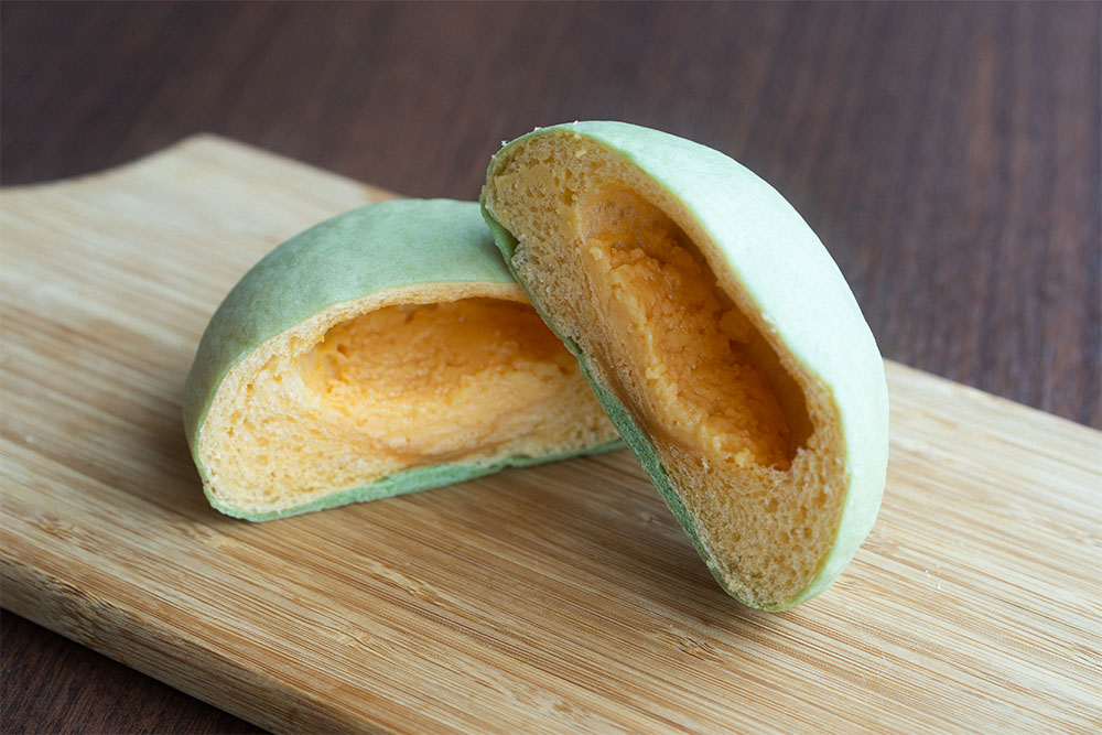 箱根スペシャルメロンパンの断面。外側は緑色、中がオレンジ色。