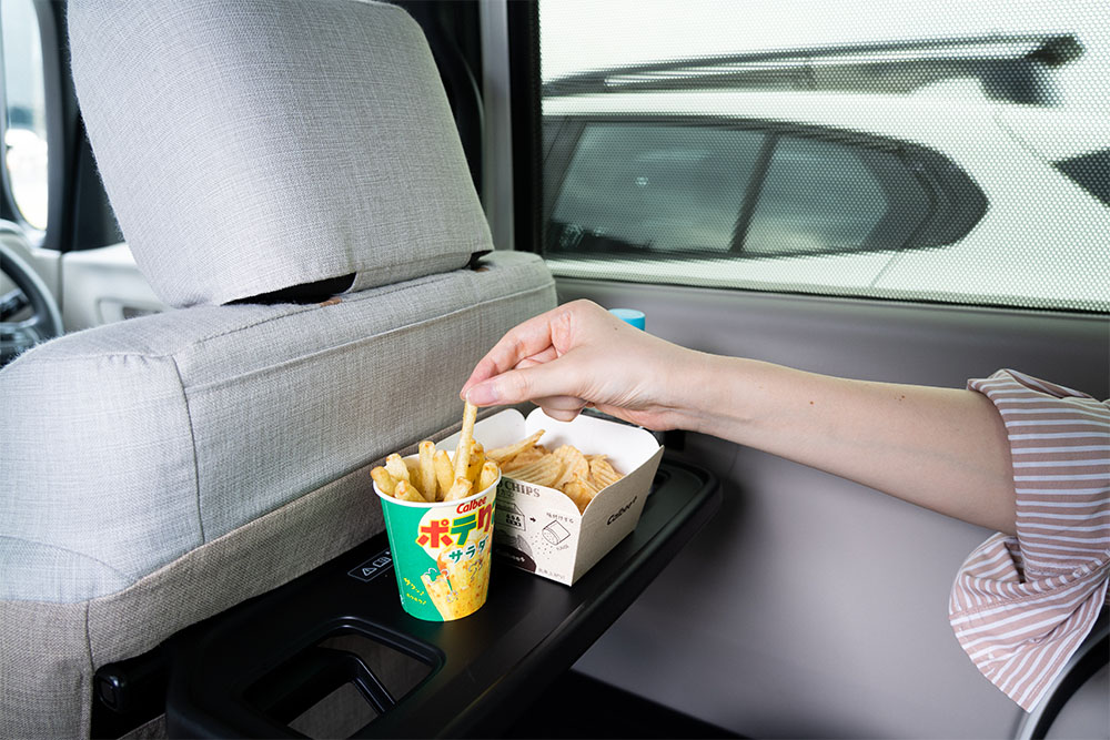 車内のシートバックテーブルでポテりこを食べている様子