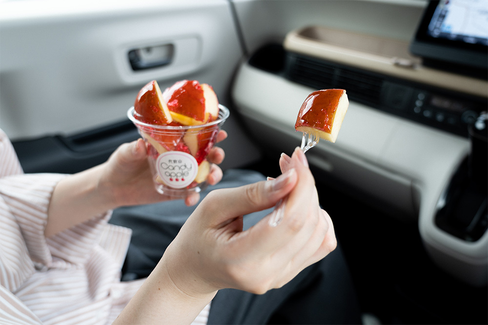 カットされたりんご飴をフォークで差し出している様子