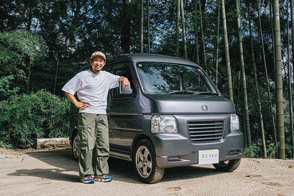 先輩から譲り受けたバモスの横で笑顔を見せるテンさん