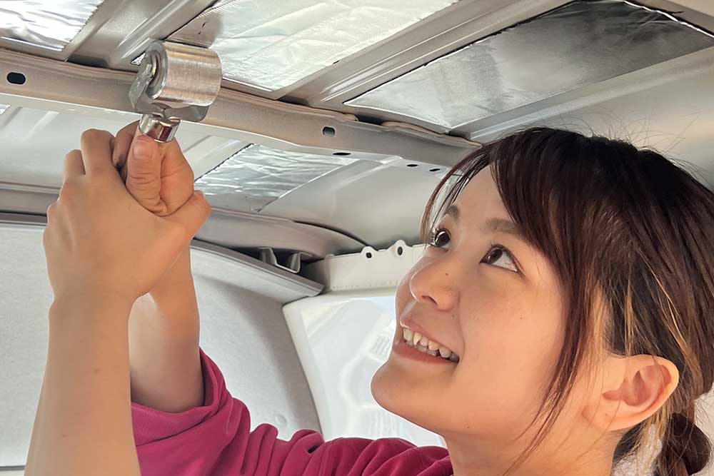 まいさんが天井の制振シートをローラーで貼っている様子