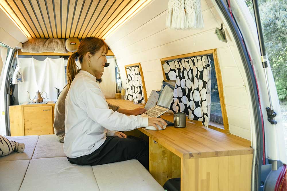 車内の側面テーブルでPCを広げ仕事をしている様子