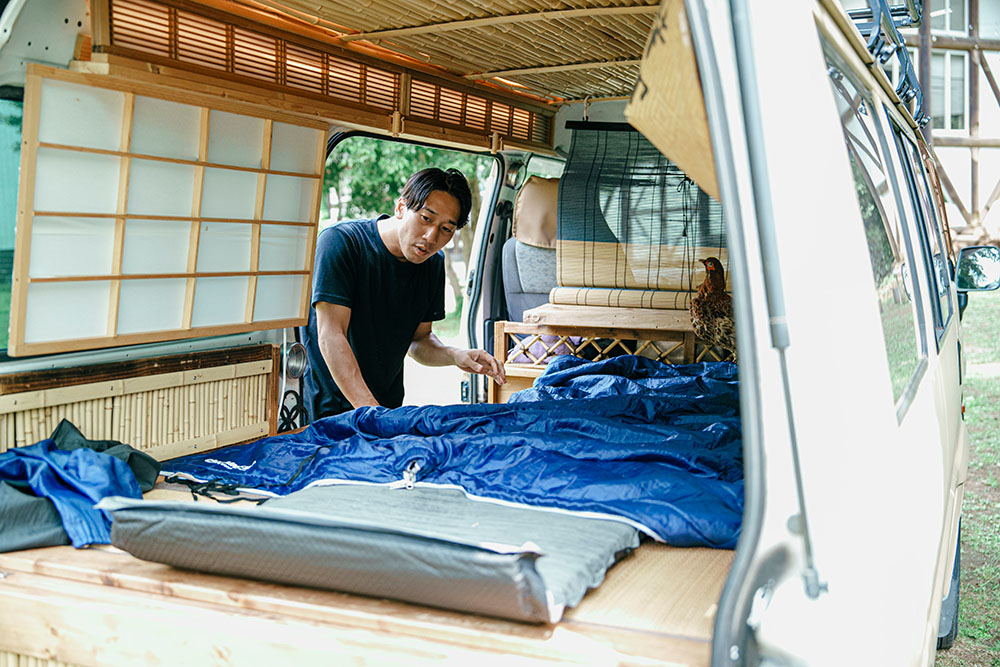 インフレーターマットと寝袋を広げるコウジロウさん