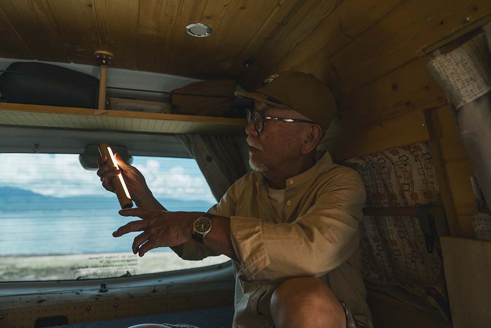 天井からぶらさがった読書灯を点灯させている様子