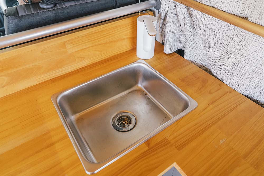 L字カウンターキッチンの角に設えられた自動水栓とシンク