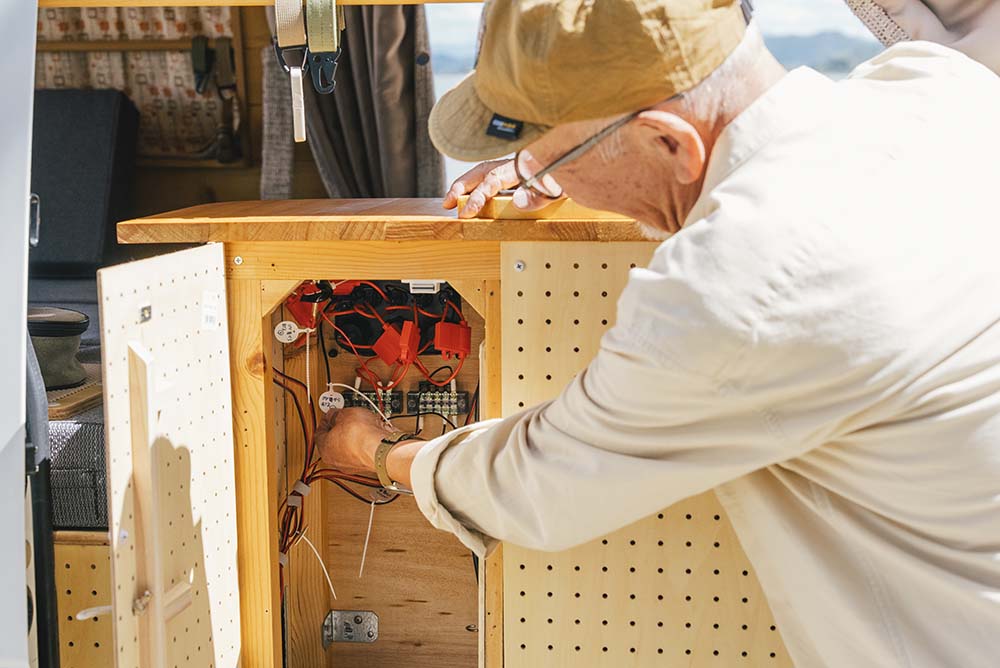 L字カウンターの裏の棚を開けているウィンピーさん